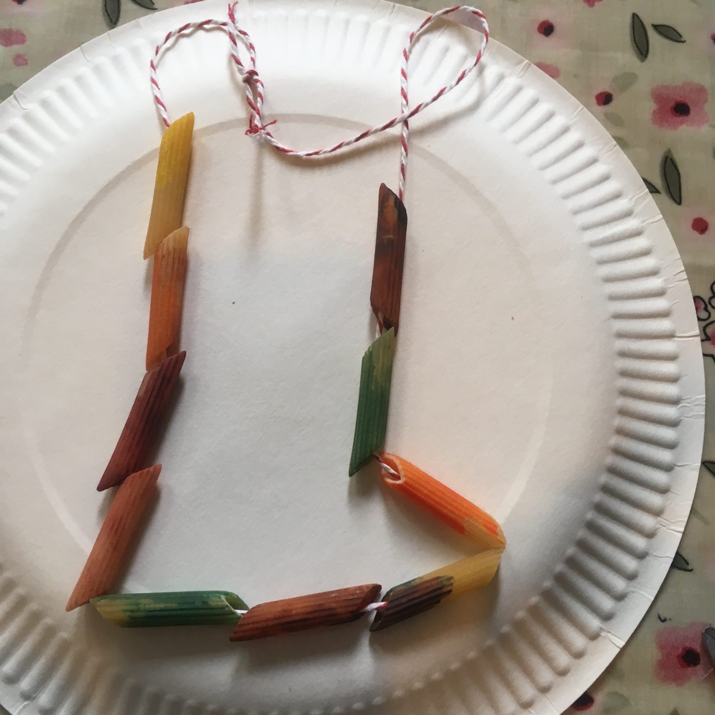 september activities for kids - a painted pasta necklace in autumn colours 