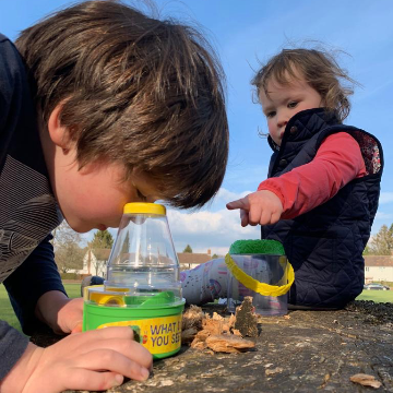 a boy looking through a bug hunting microscope