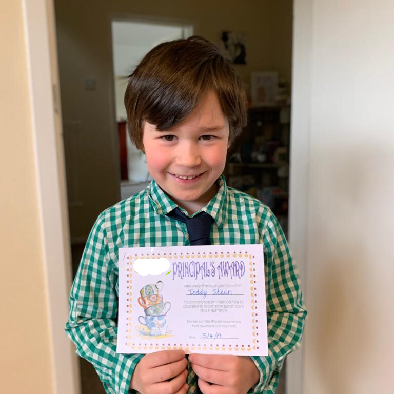 boy in shirt and tie holding a certificate
