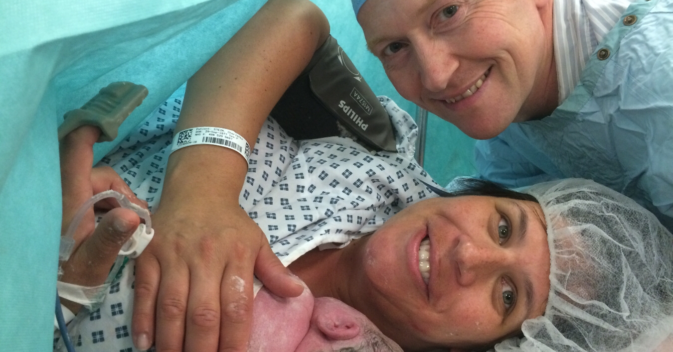 parents holding newborn in operating theatre