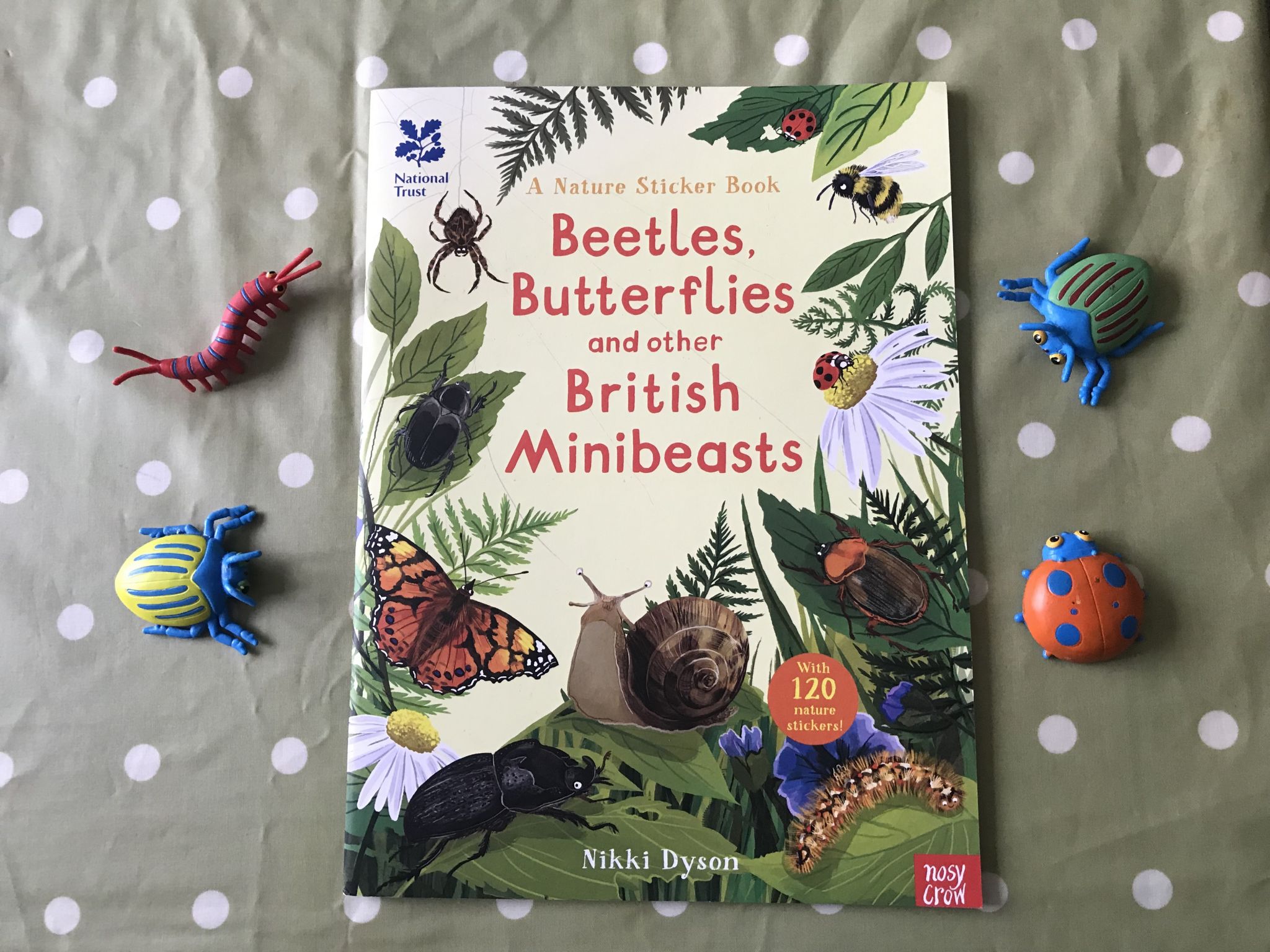 a flatly photo of a bugs and beetles sticker book with some plastic bugs