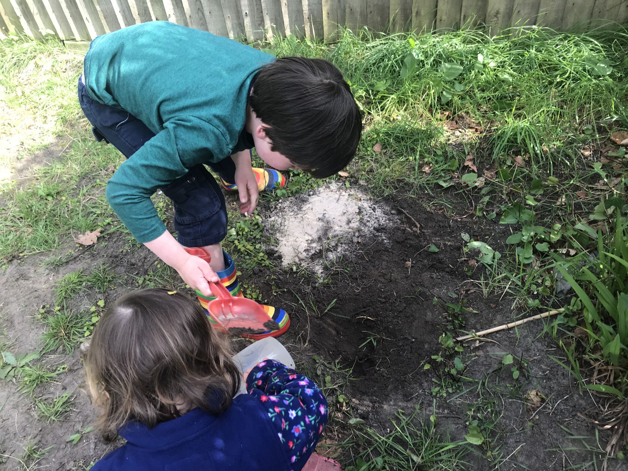 two children digging up the soil