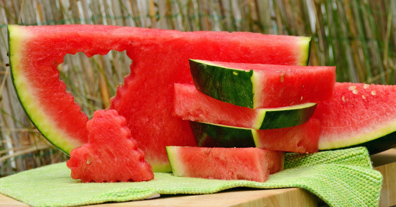 A watermelon cut up with a heart shape 