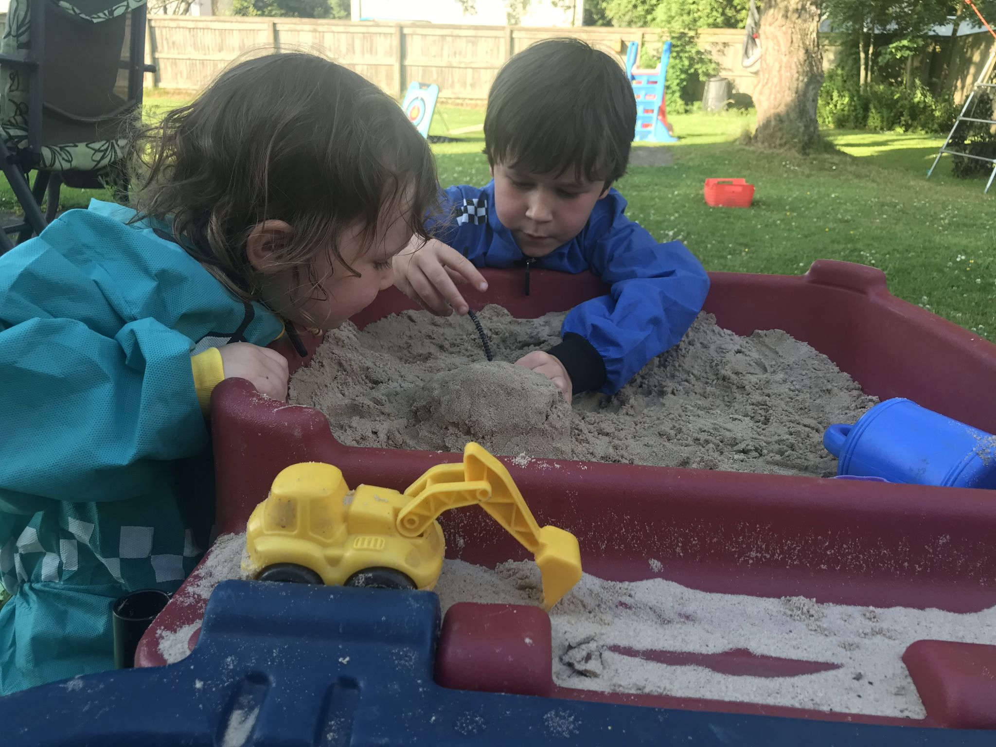 two children playing in a sand table