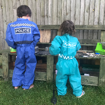 Two children playing in a mud kitchen