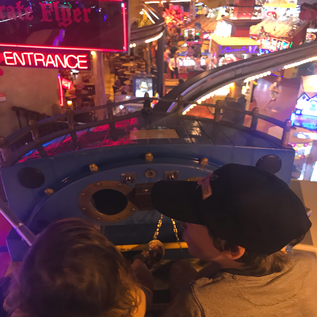 2 children on a monorail ride in an arcade