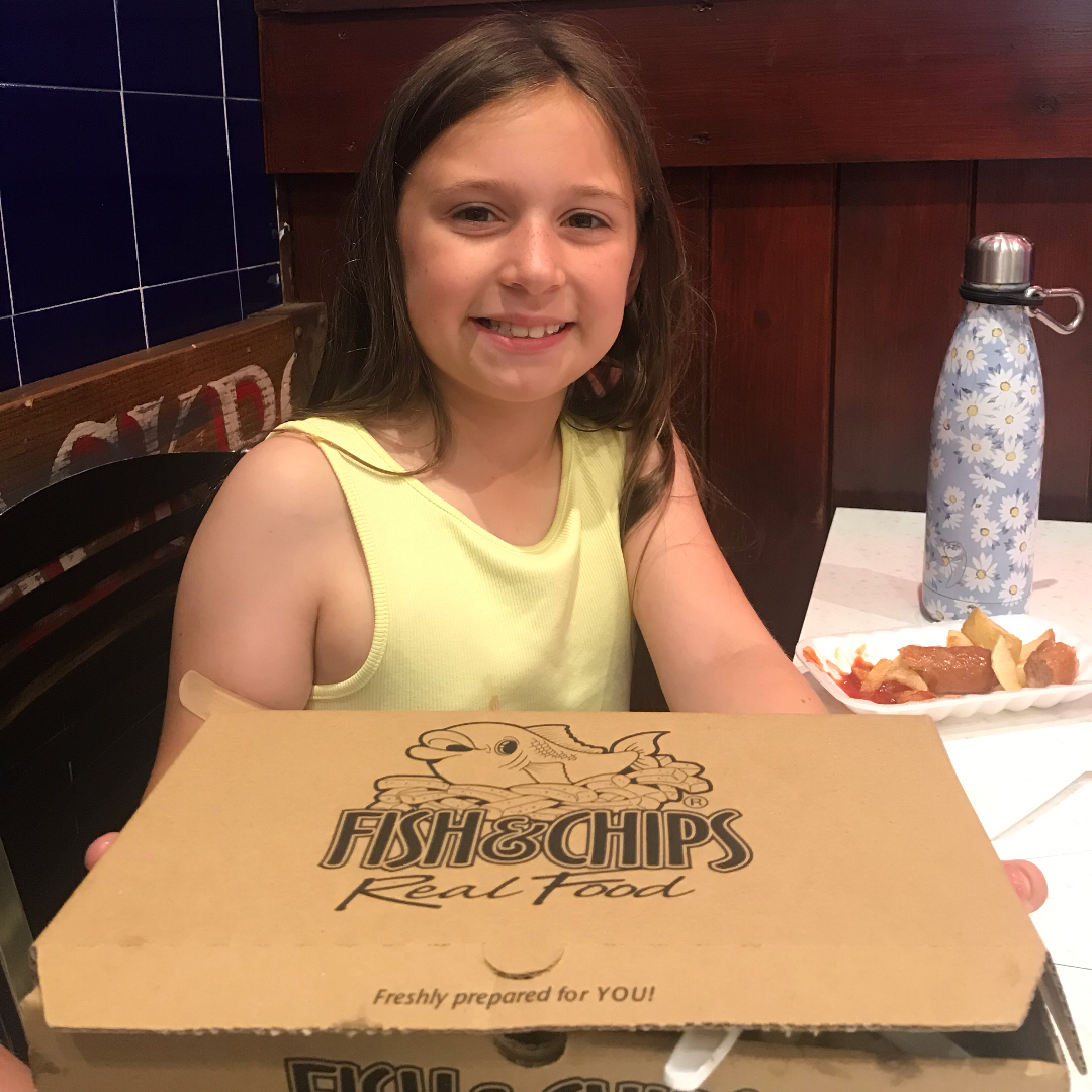 A girl with a box of fish and chips