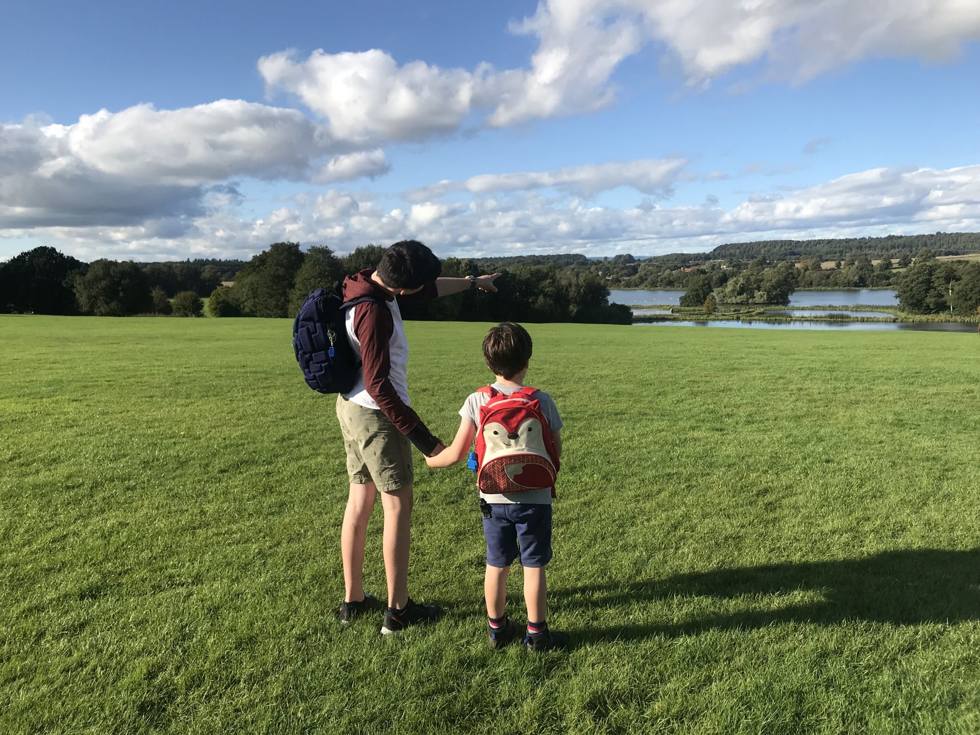 two boys looking at a lake