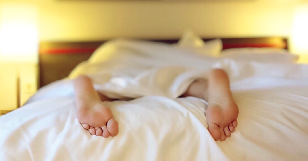 Childs feet poking out of bed