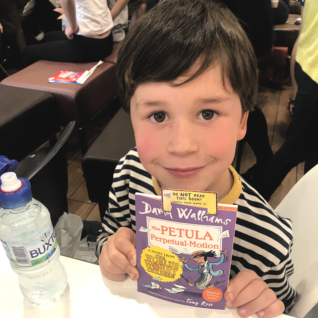 a child with a happy reader posing for photo