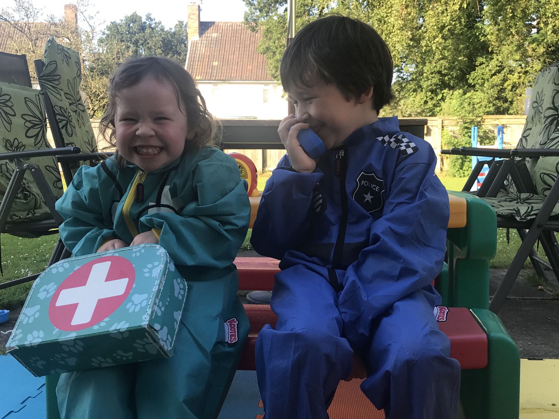 two children dressed in play overalls