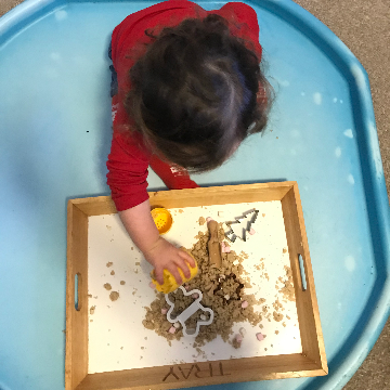 a child playing with dough for a Christmas baby and toddler activity
