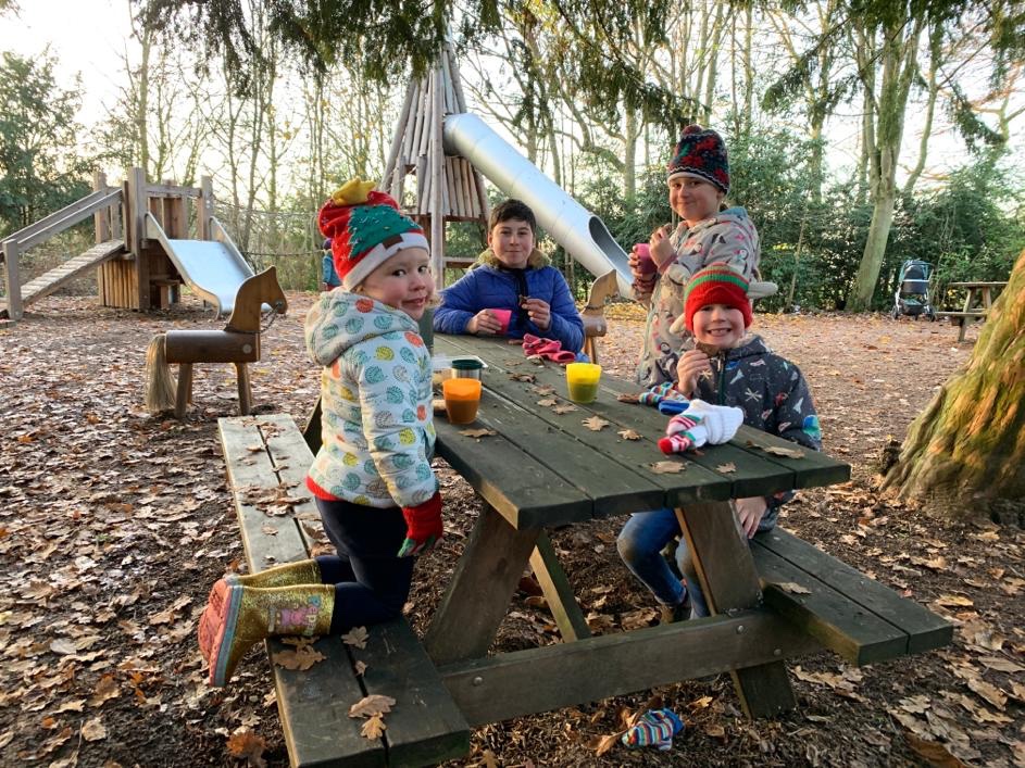 children on a picnic bench in a wintery wood