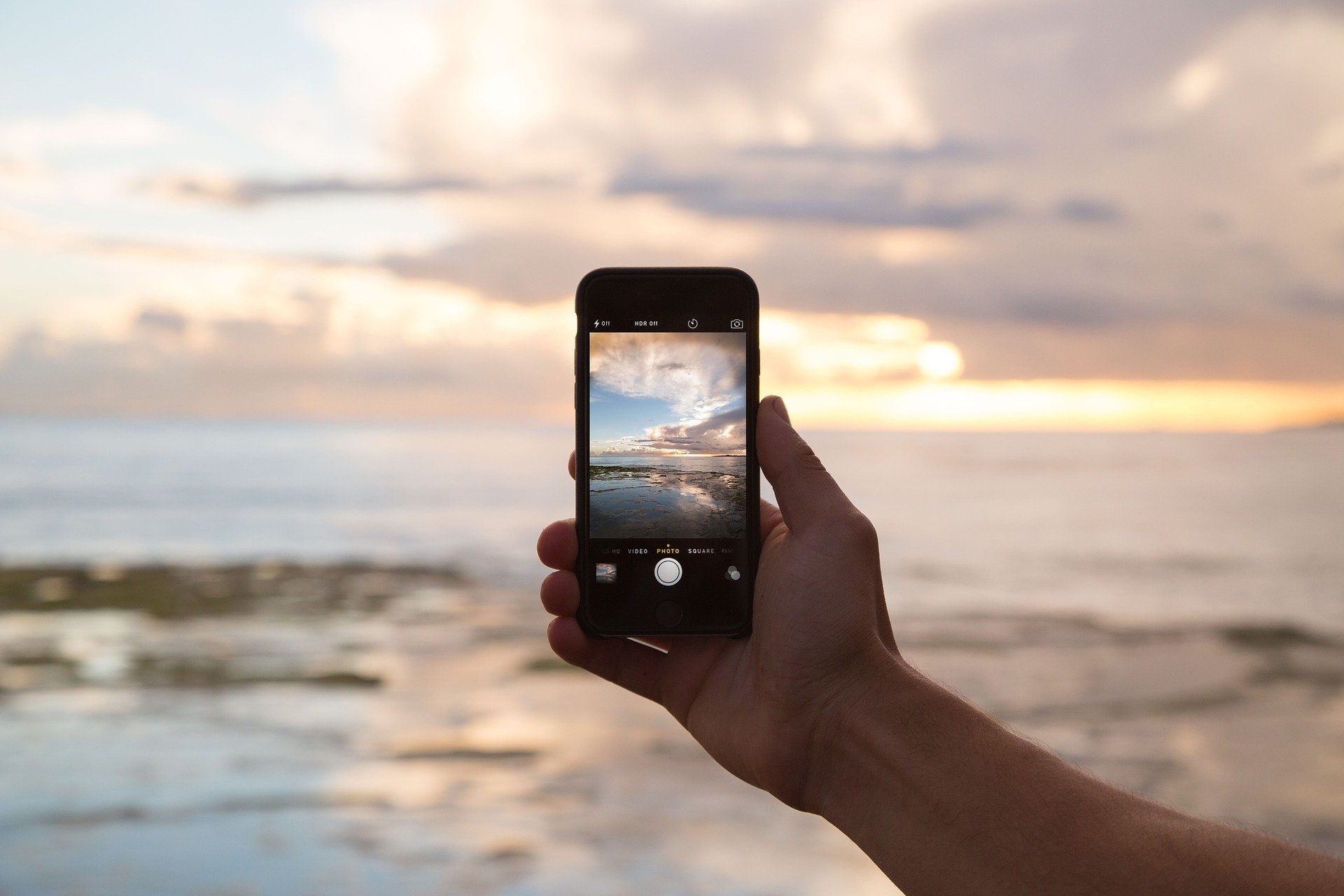 an iPhone taking a picture of the sea with the view in shot also. 