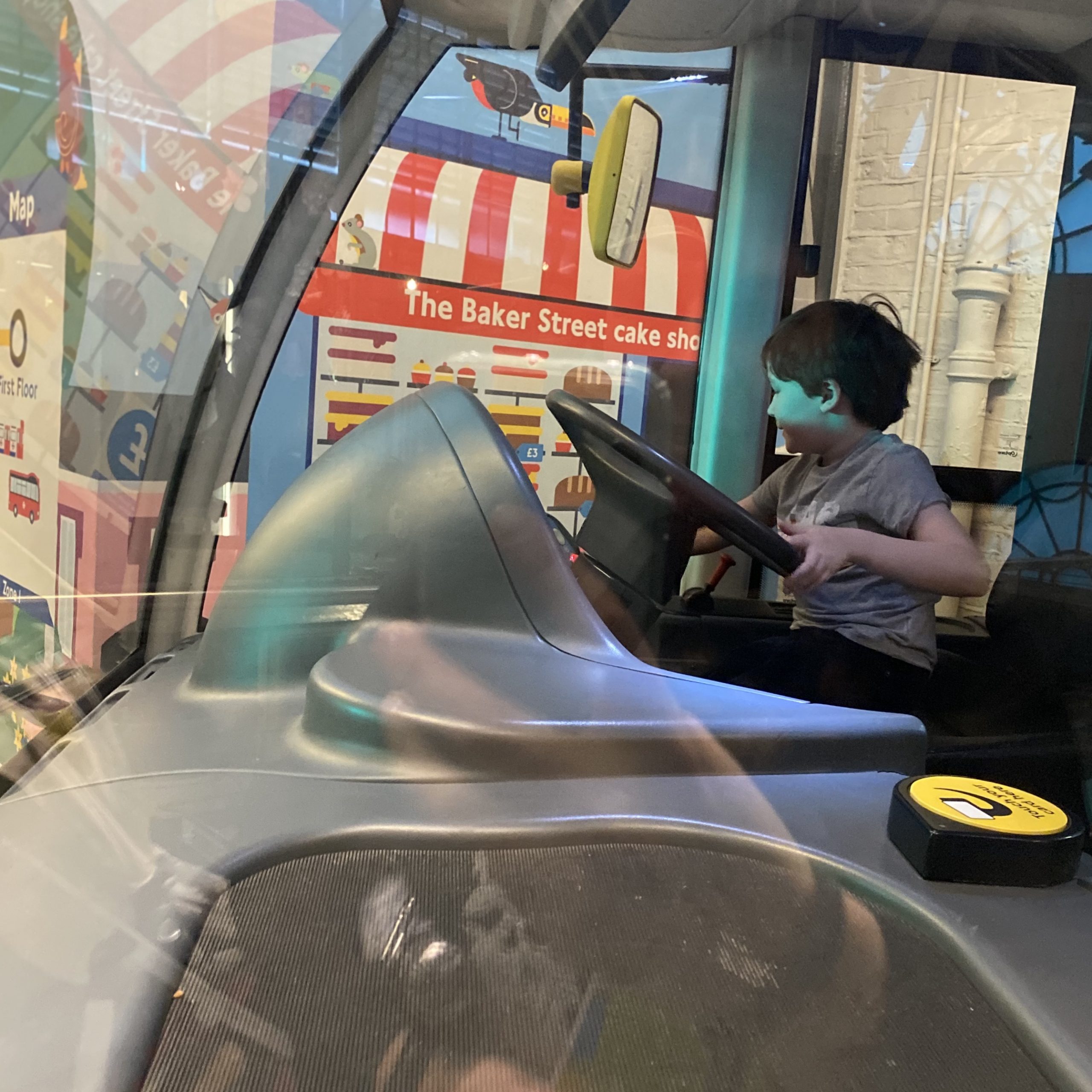 A boy driving a play bus at the LT museum