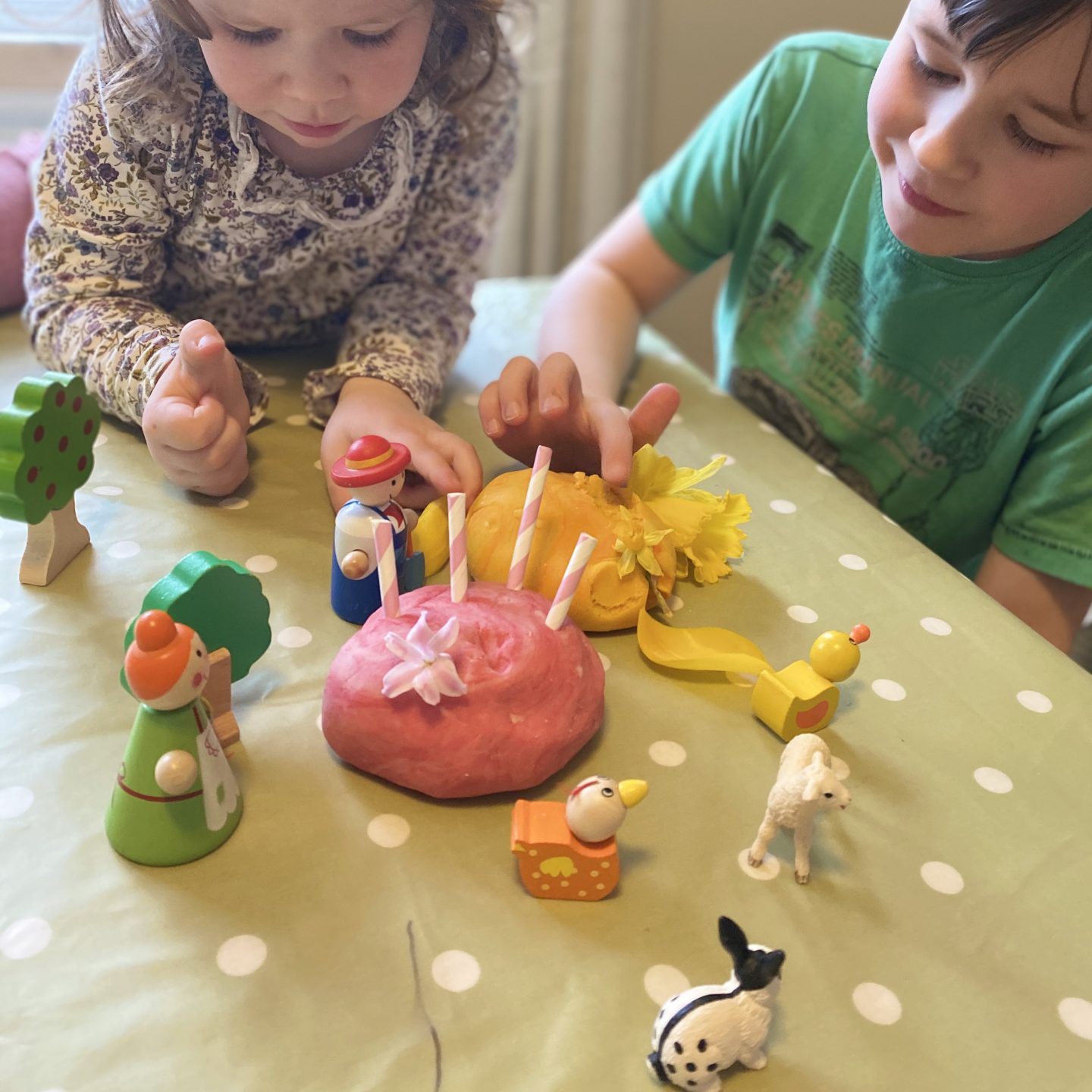 Playdough and farm animals with two children playing