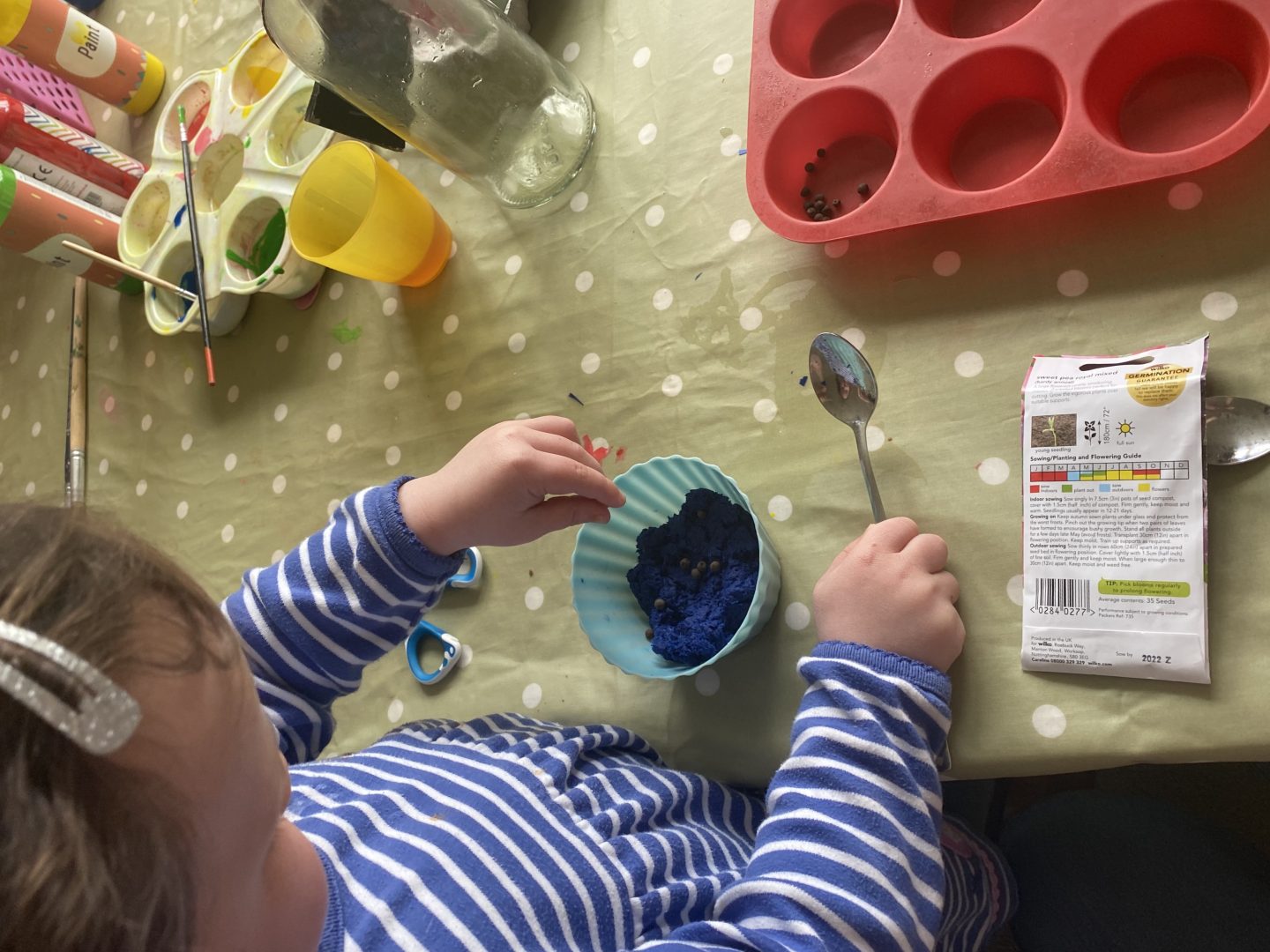 a child putting seeds in a bowl of pulped paper 