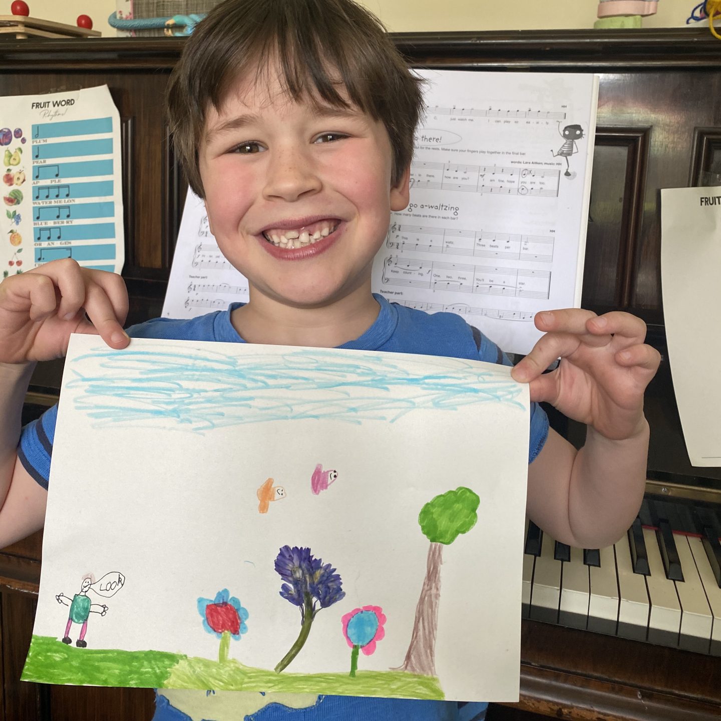 Home school creations - a boy holding a flower picture and smiling proudly