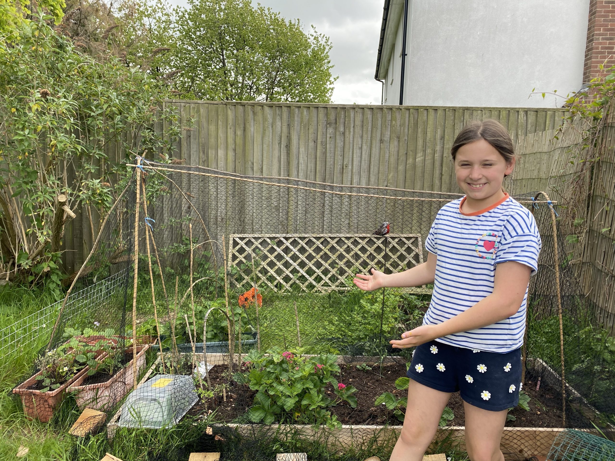 garden projects with a young girl posing by a veg patch
