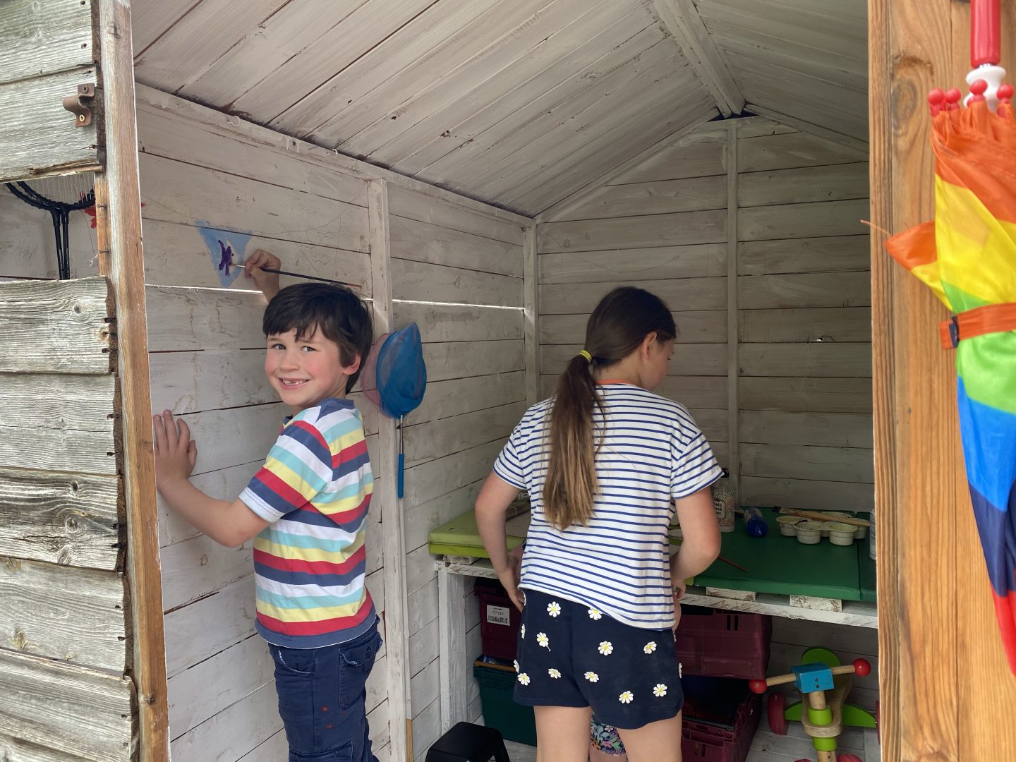 garden projects with a young boy painting a shed