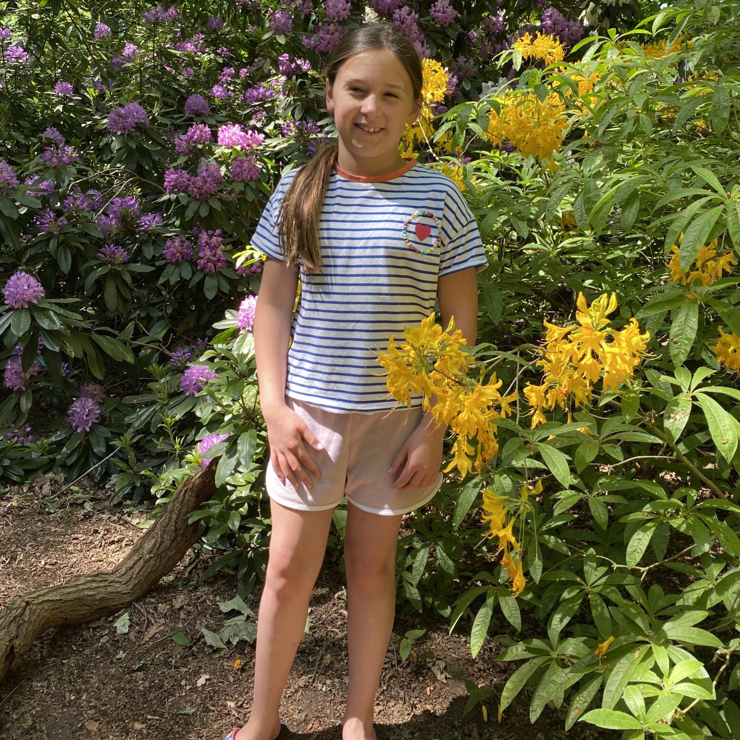 Picnic time with a girl standing by some lovely flowers