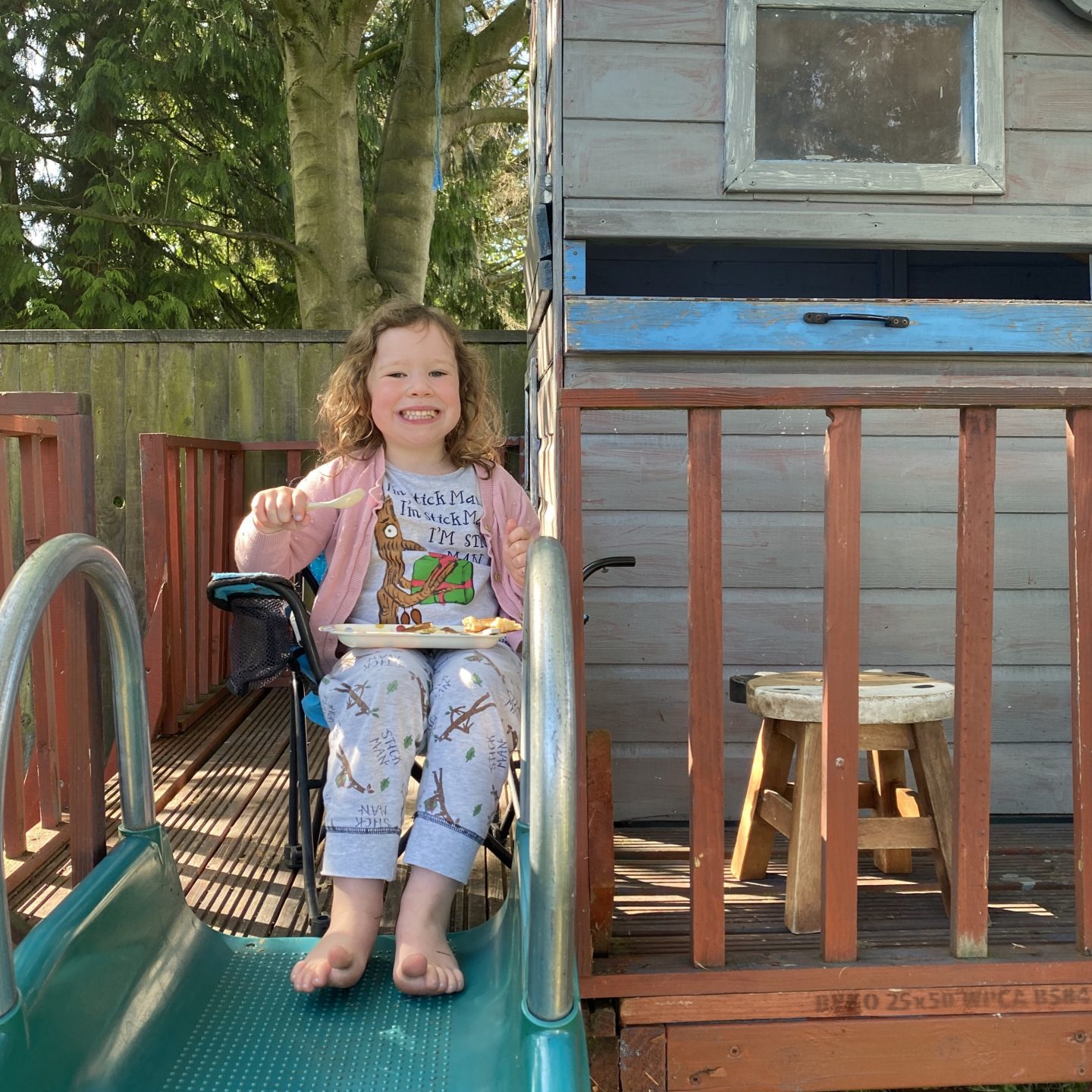 A small child on a treehouse having pancakes 