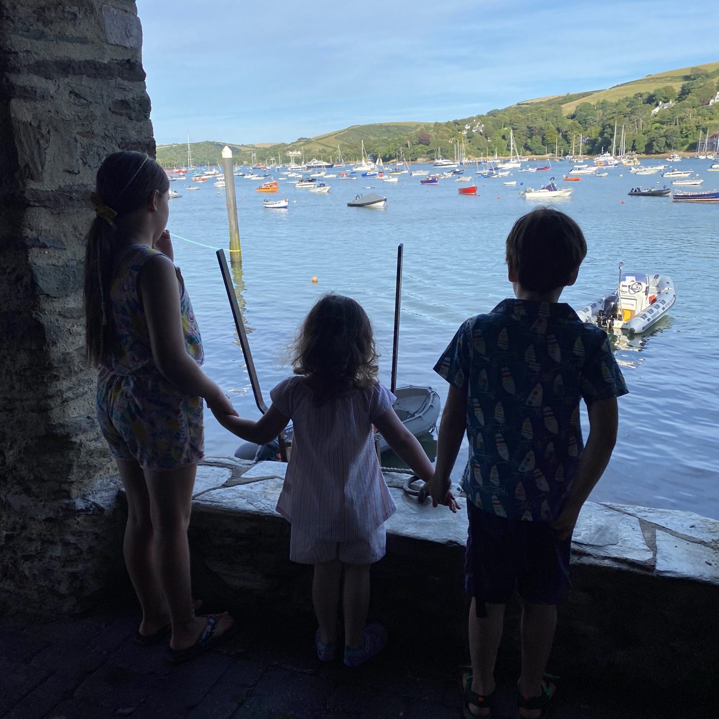 A view from Salcombe harbour with 3 children looking at boats 