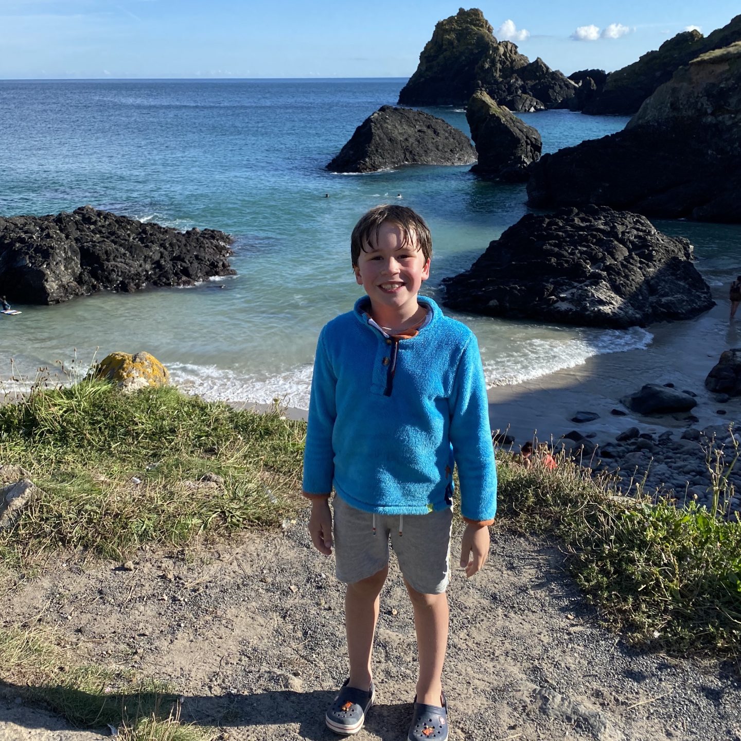 Family road trip in Cornwall with a child stood by the beach in Cornwall