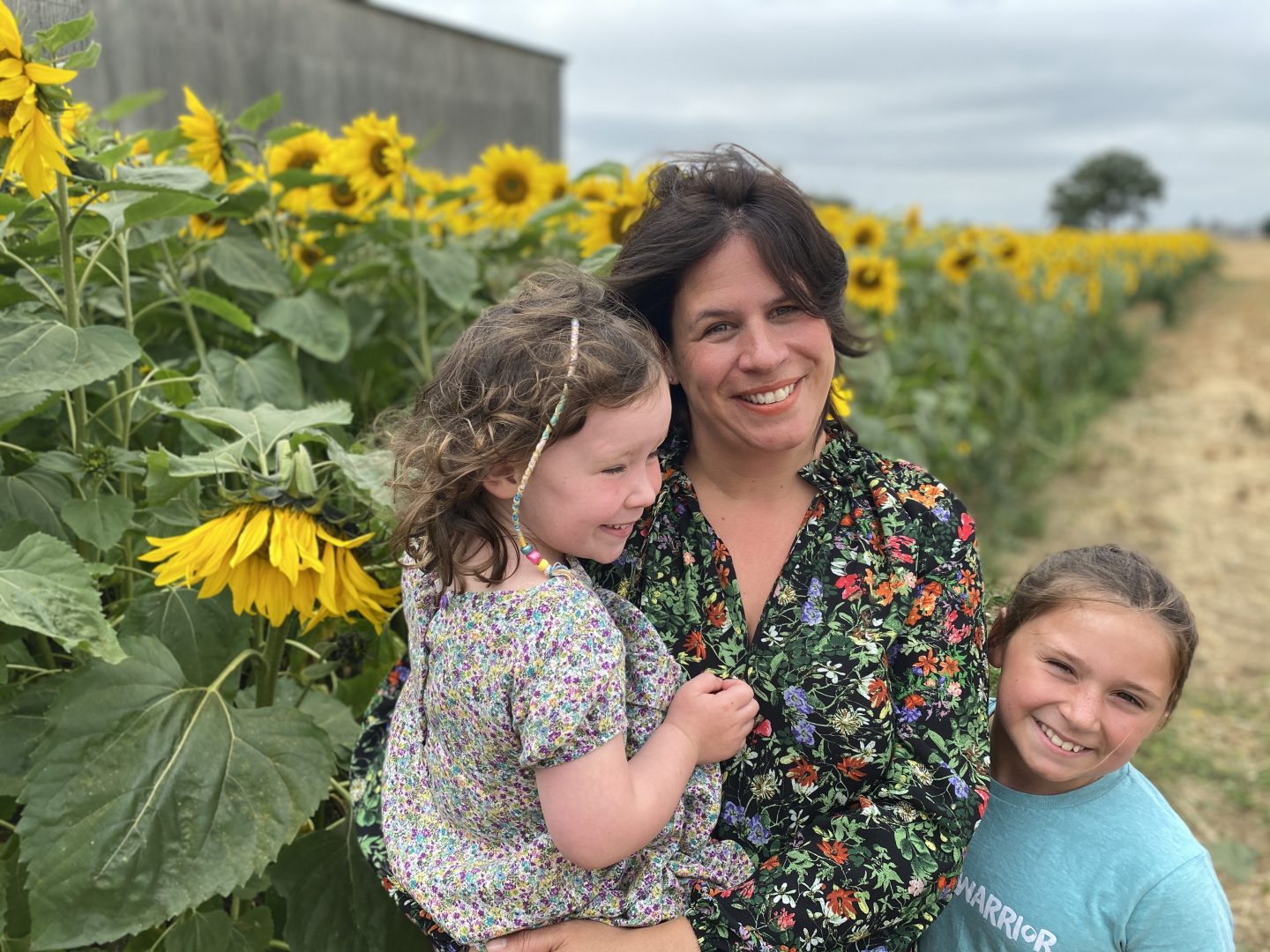 Sunflower field in Yorkshire  with a Mum and 2 girls smiling 