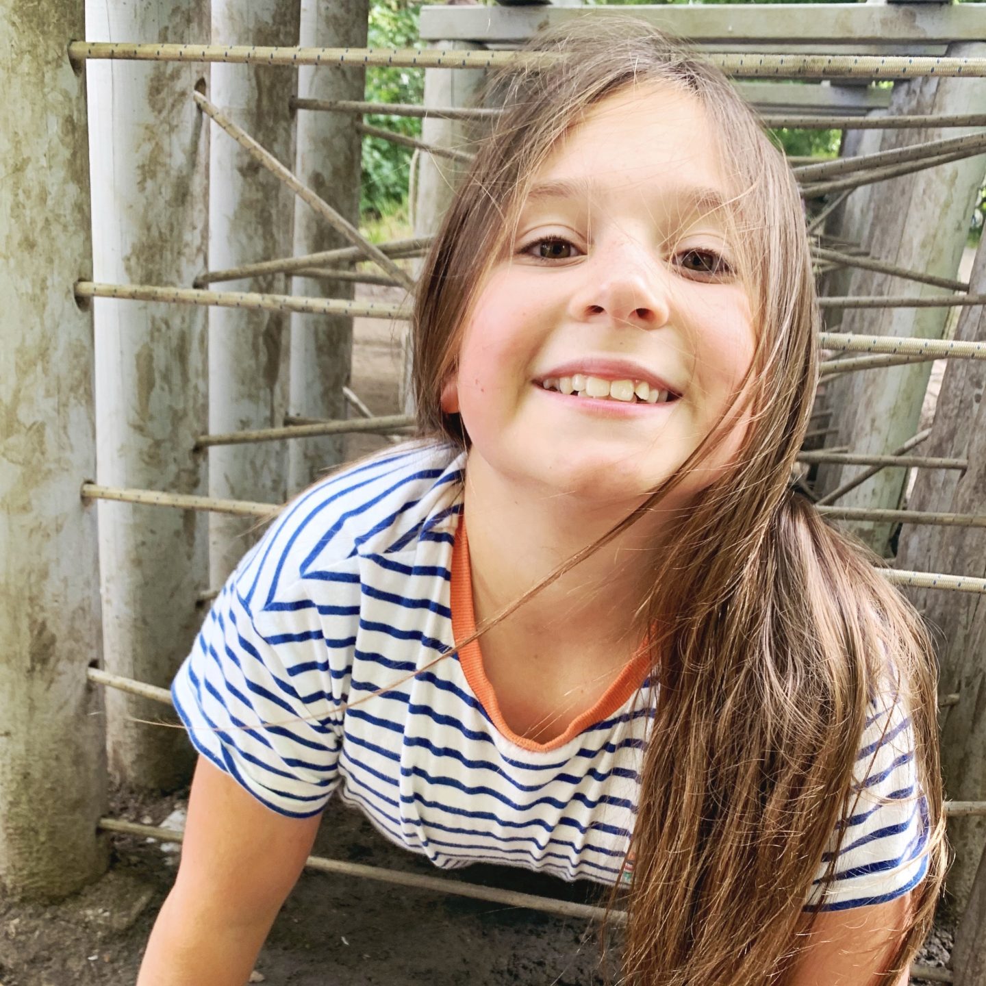 A young girl grinning at the camera on her last week of summer