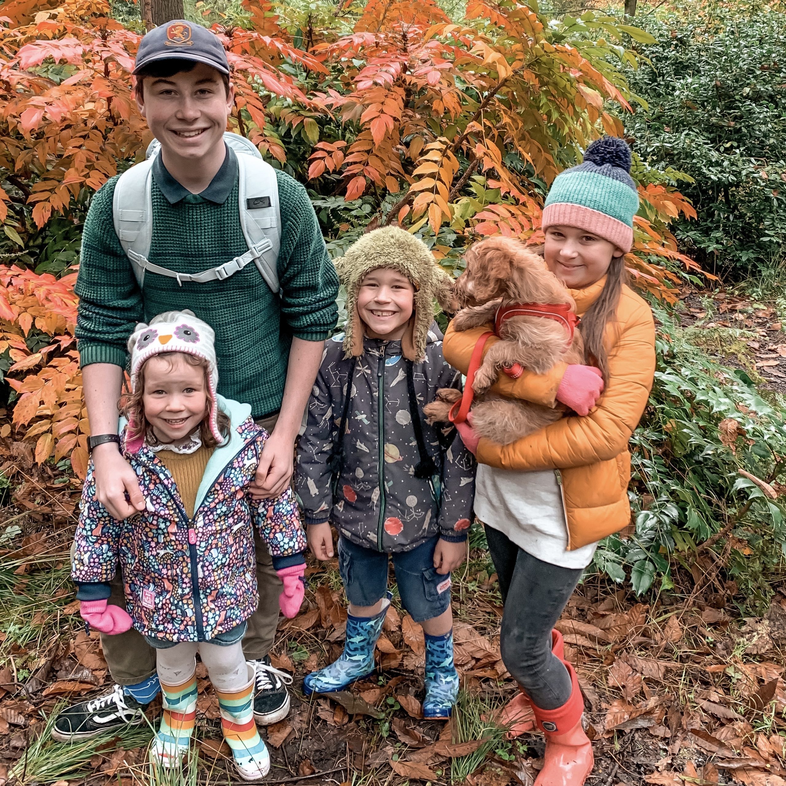 a slow weekend with 4 kids and a puppy in the woods posing by an orange tree