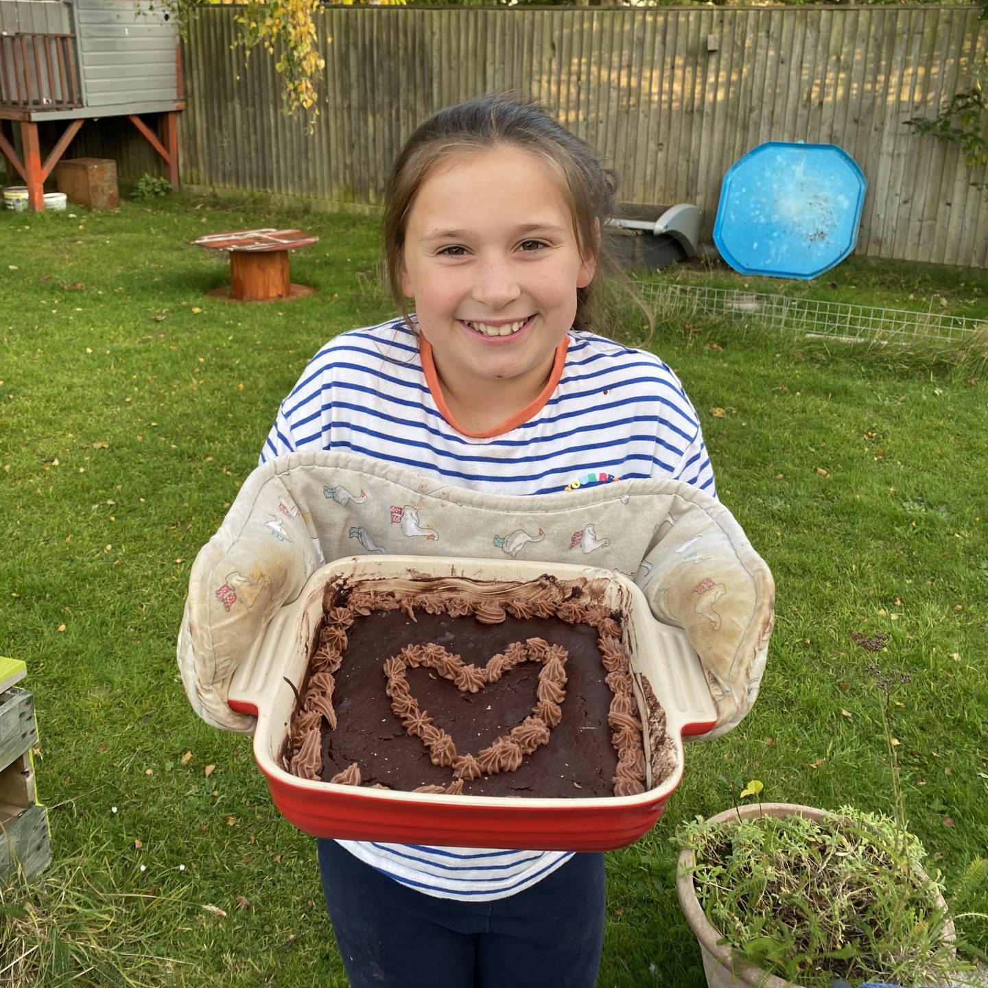 A girl holding up a cake 