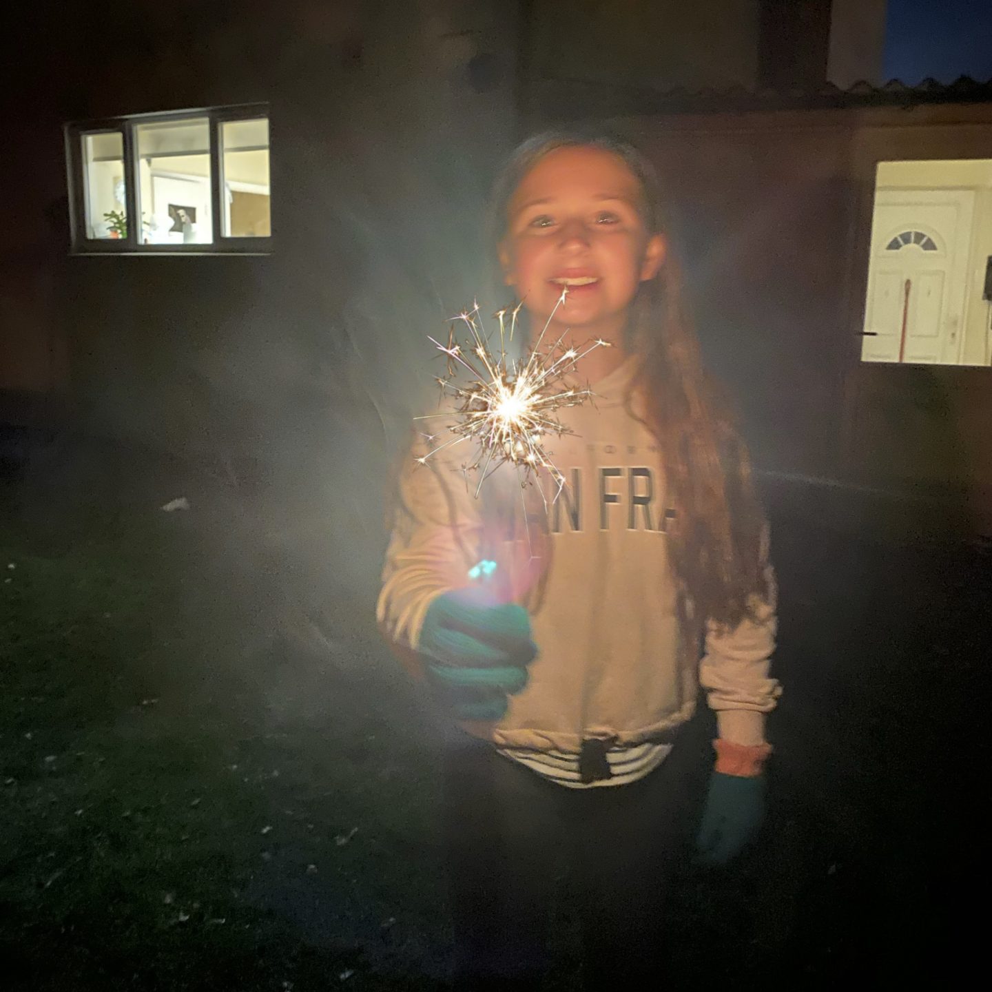 A girl holding a sparkler in the dark 