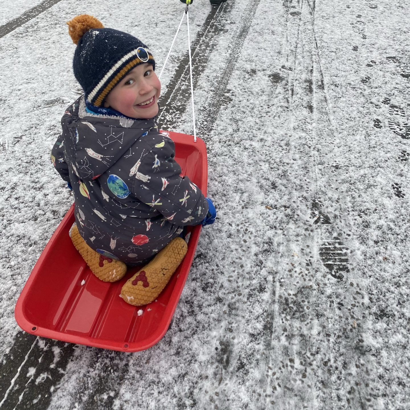 a young boy looking happy on a sledge