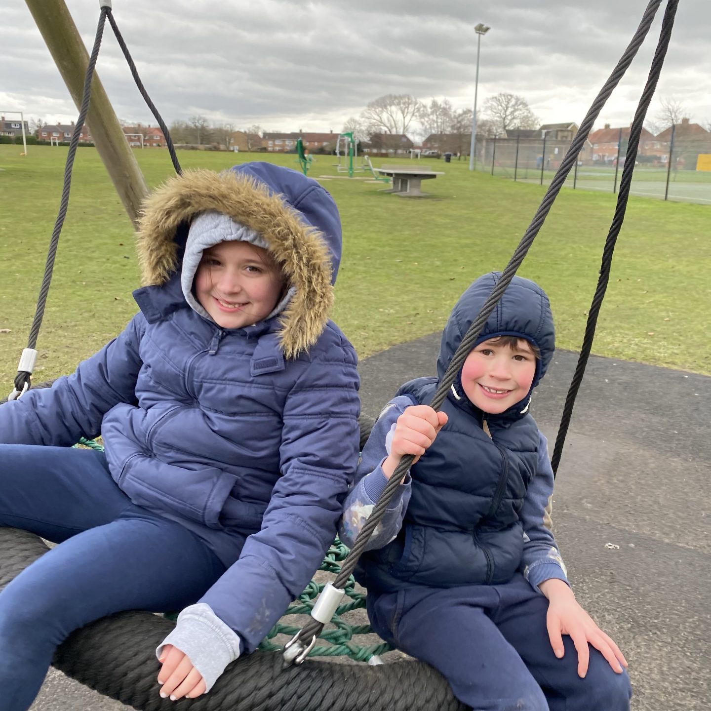 Playground trip with 2 children on a flying saucer swing