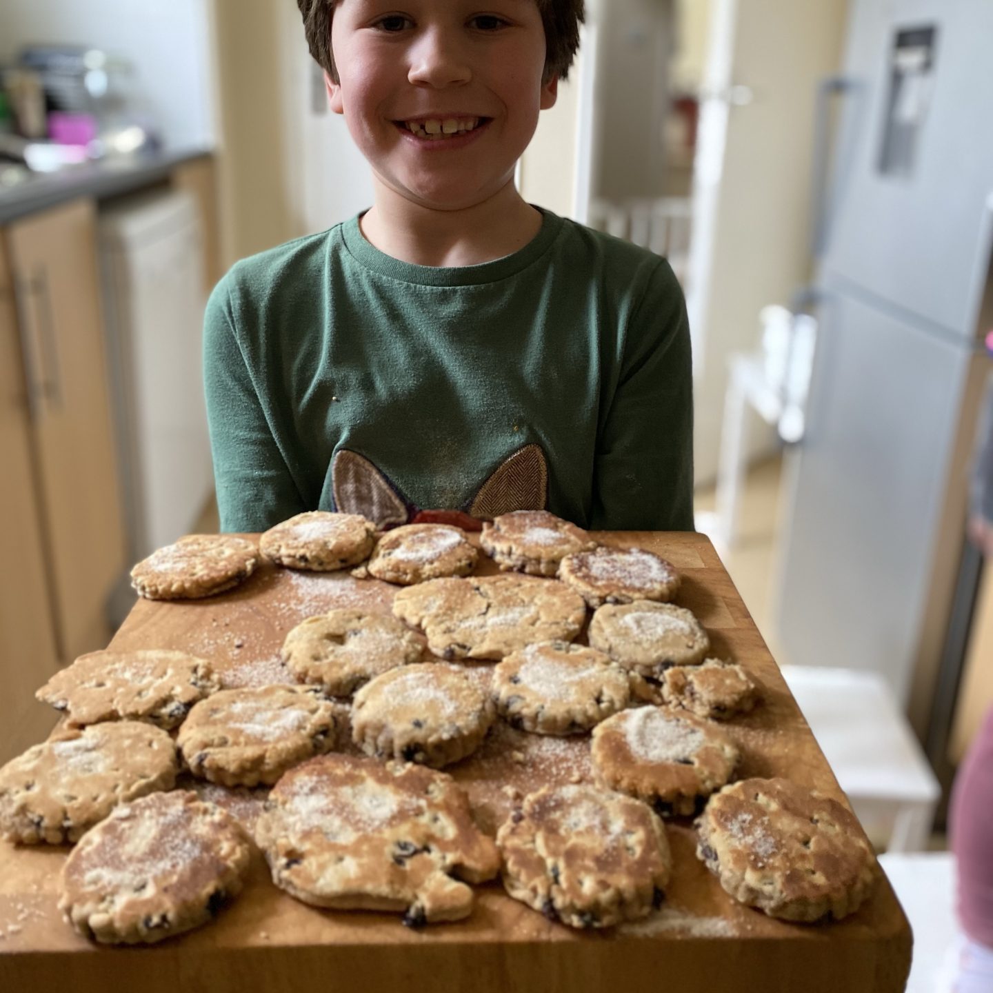 a young boy holding Welsh cakes