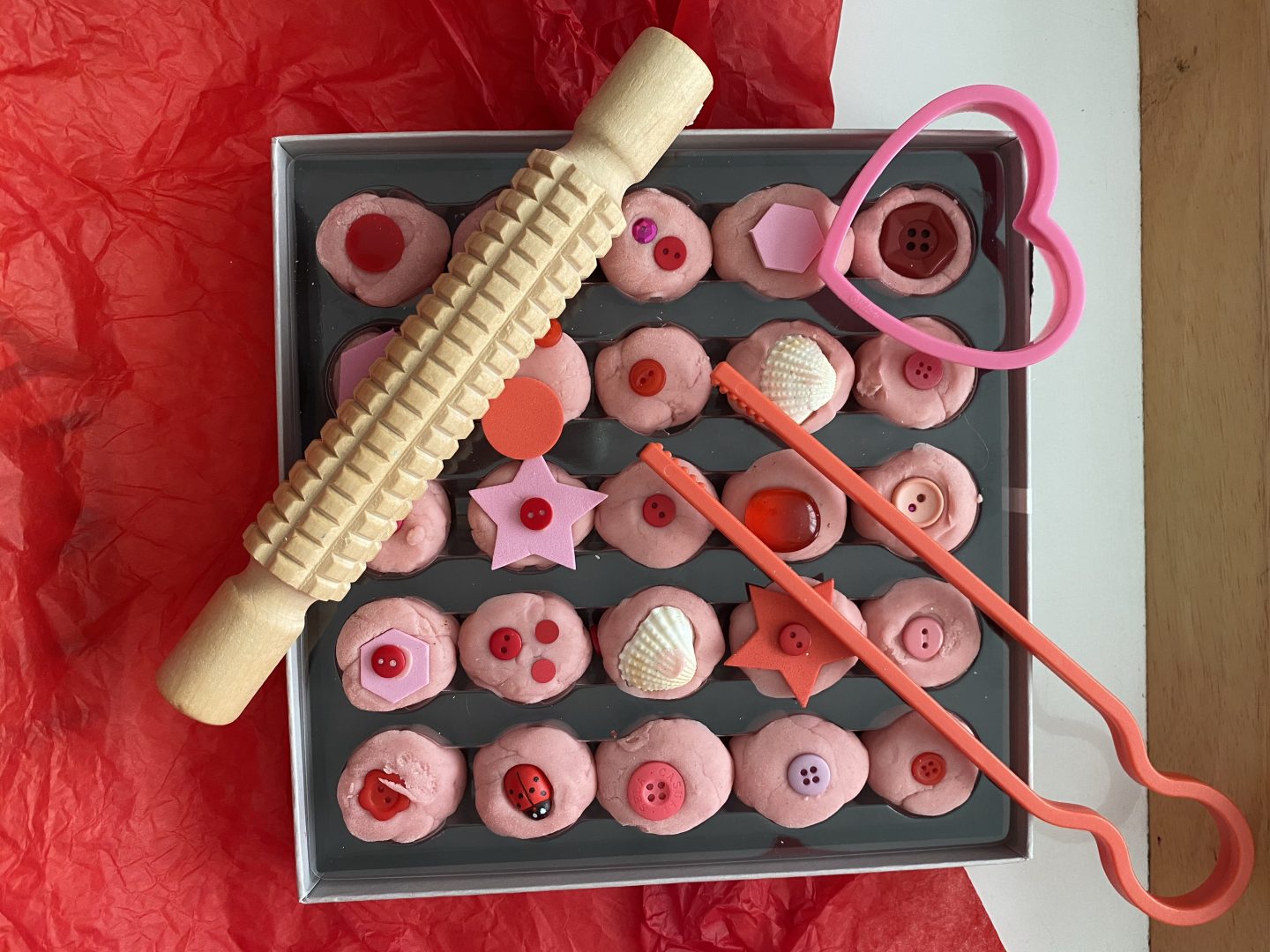 February activities for kids with a box of valentines Playdough chocolates with rolling pin, cookie cutter and chopsticks 