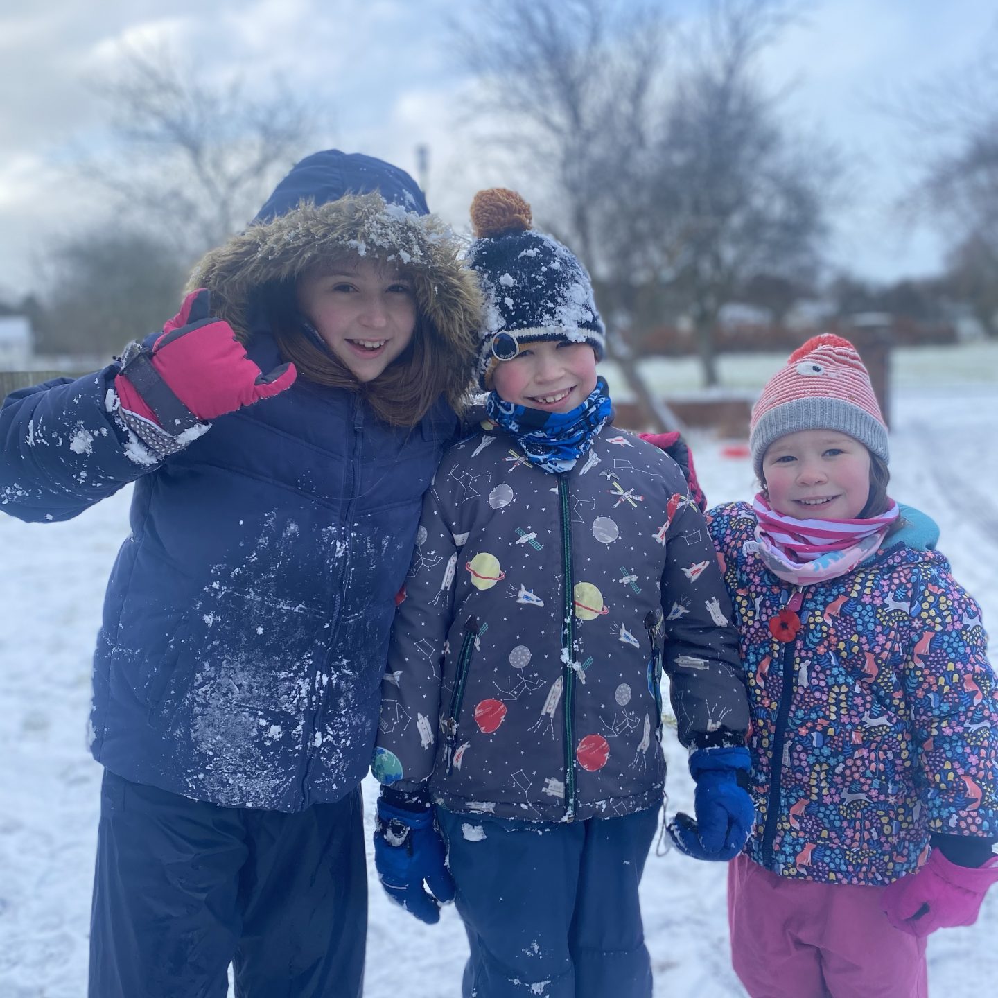 3 children sledging in the snow