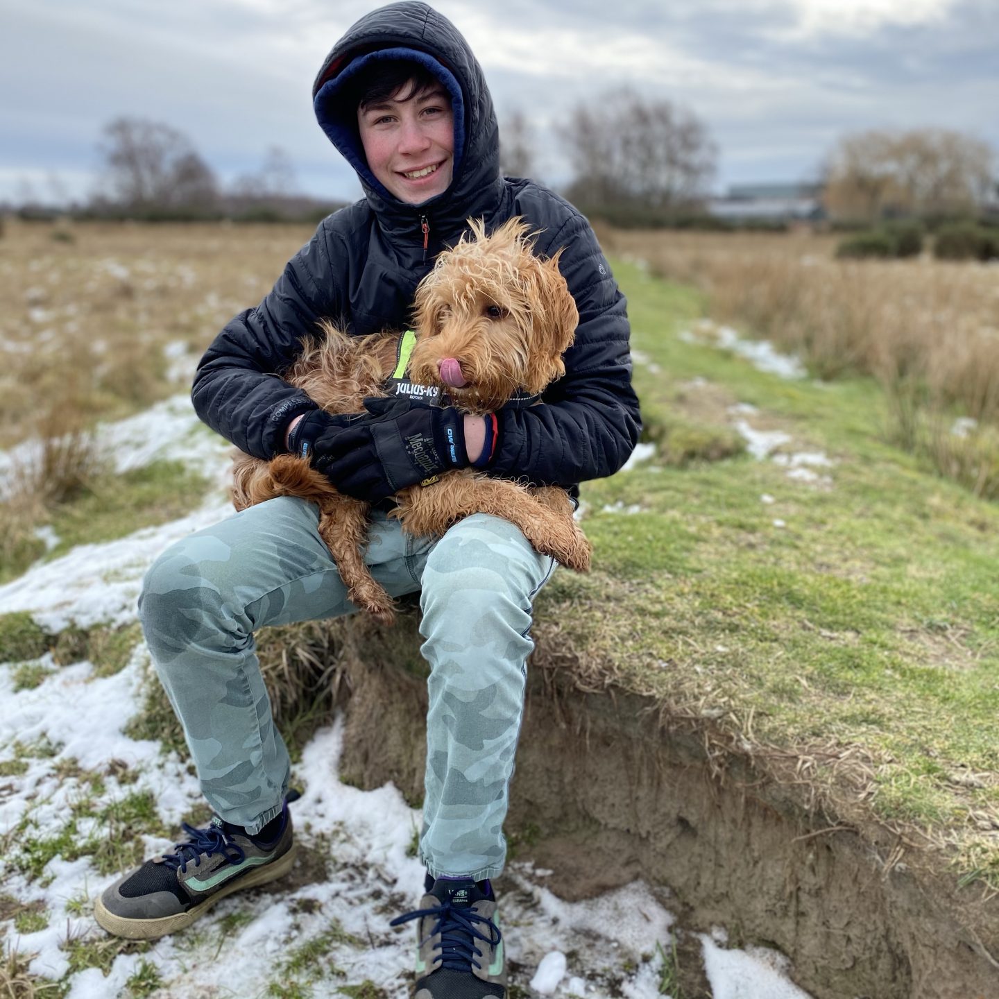 a teenage boy sat on a walk with his dog