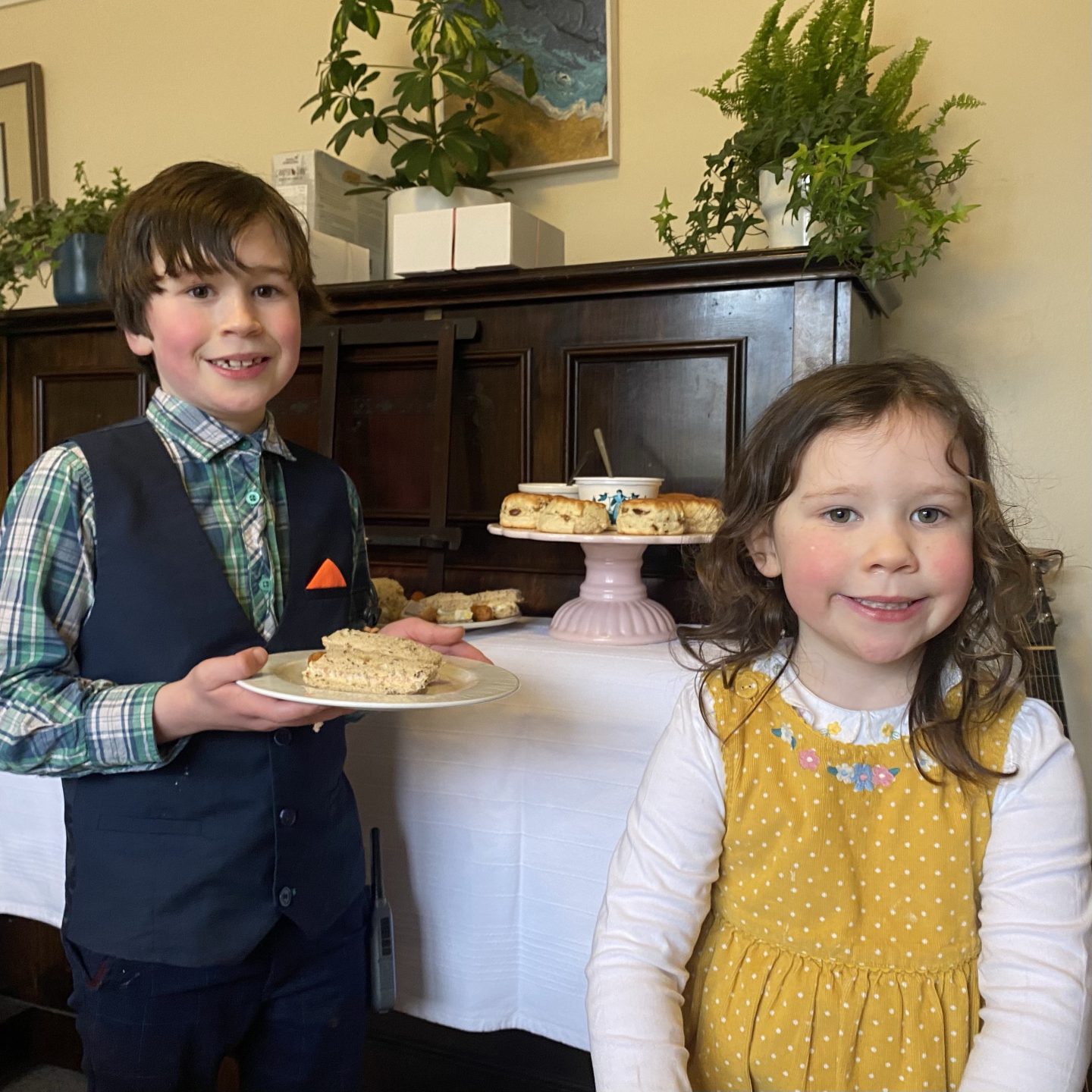 Back to routine! Then it was Mother's Day. A photo of 2 children smiling by an afternoon tea all dressed up smart.