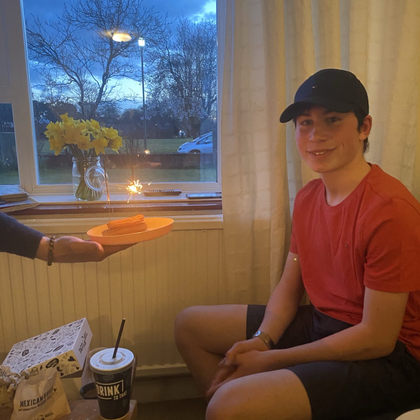 another birthday in lockdown with a boy smiling at the camera and having a desert with a sparkler presented to him