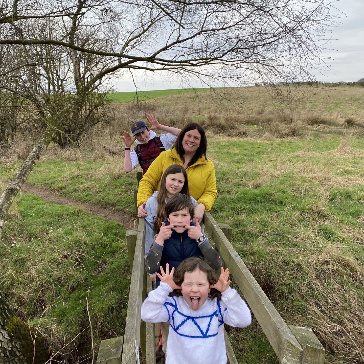Mum and 4 kids on a bridge outdoors after a week of homeschool