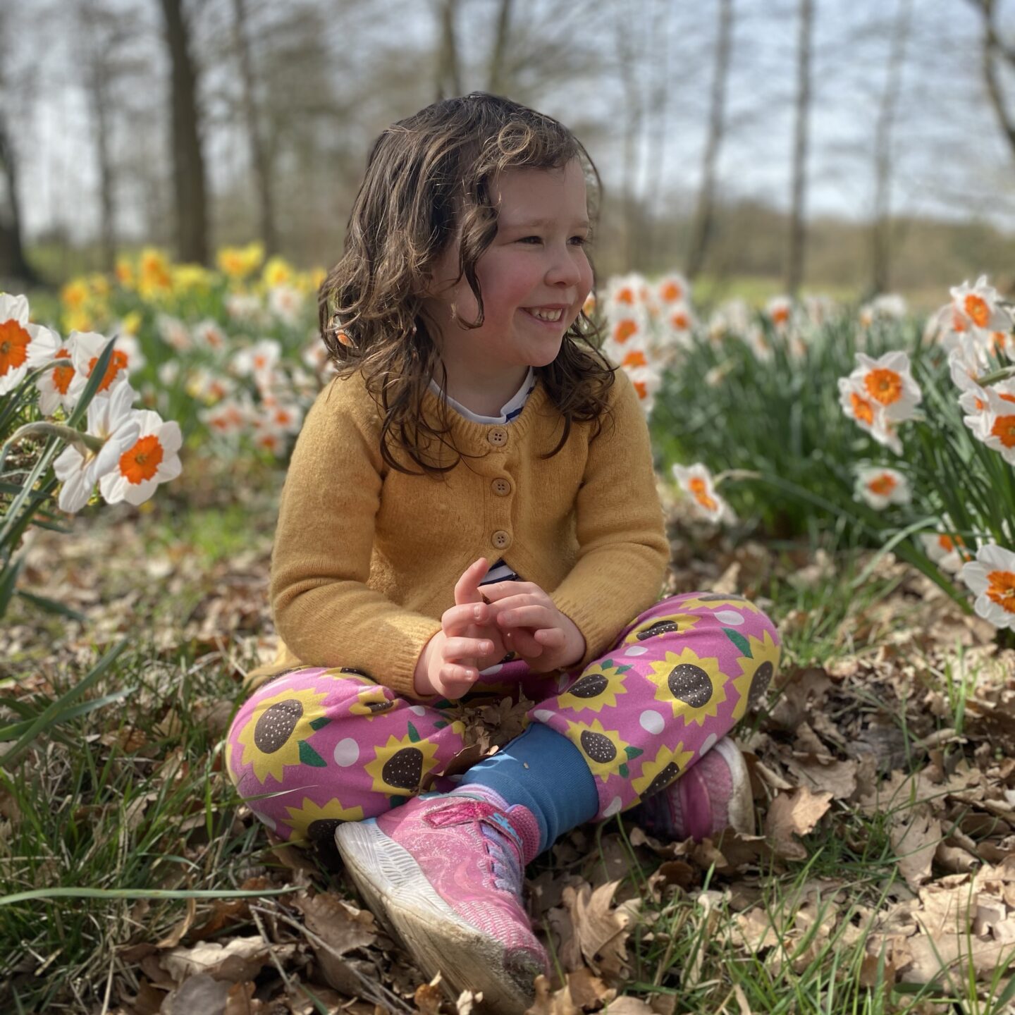 A positive week with a girl sat smiling in a patch of daffodils