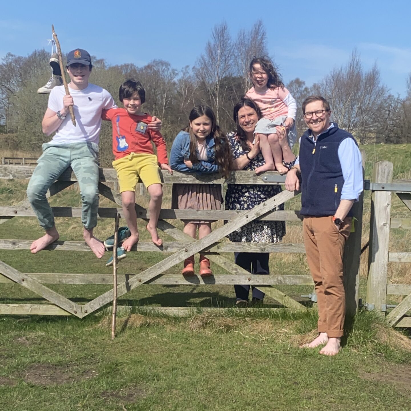 A positive week with a family of 6 all stood or sat on a five bar gate smiling to the camera in the countryside