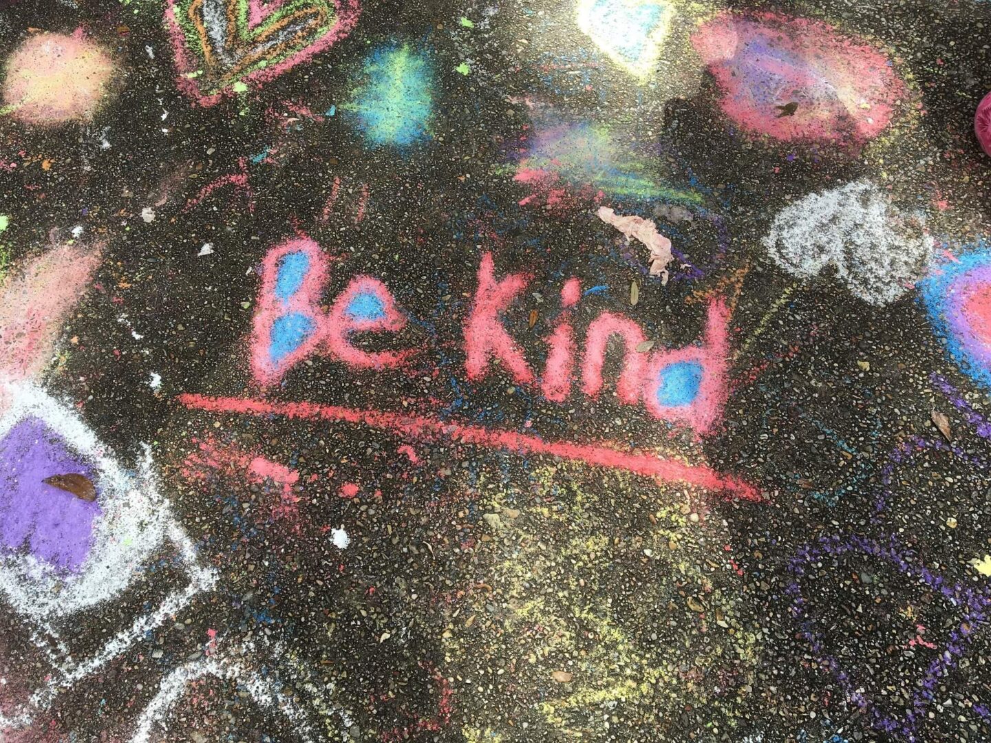 Moral values with your child - This is a picture of a a pavement covered in chalk with the message be kind written on it
