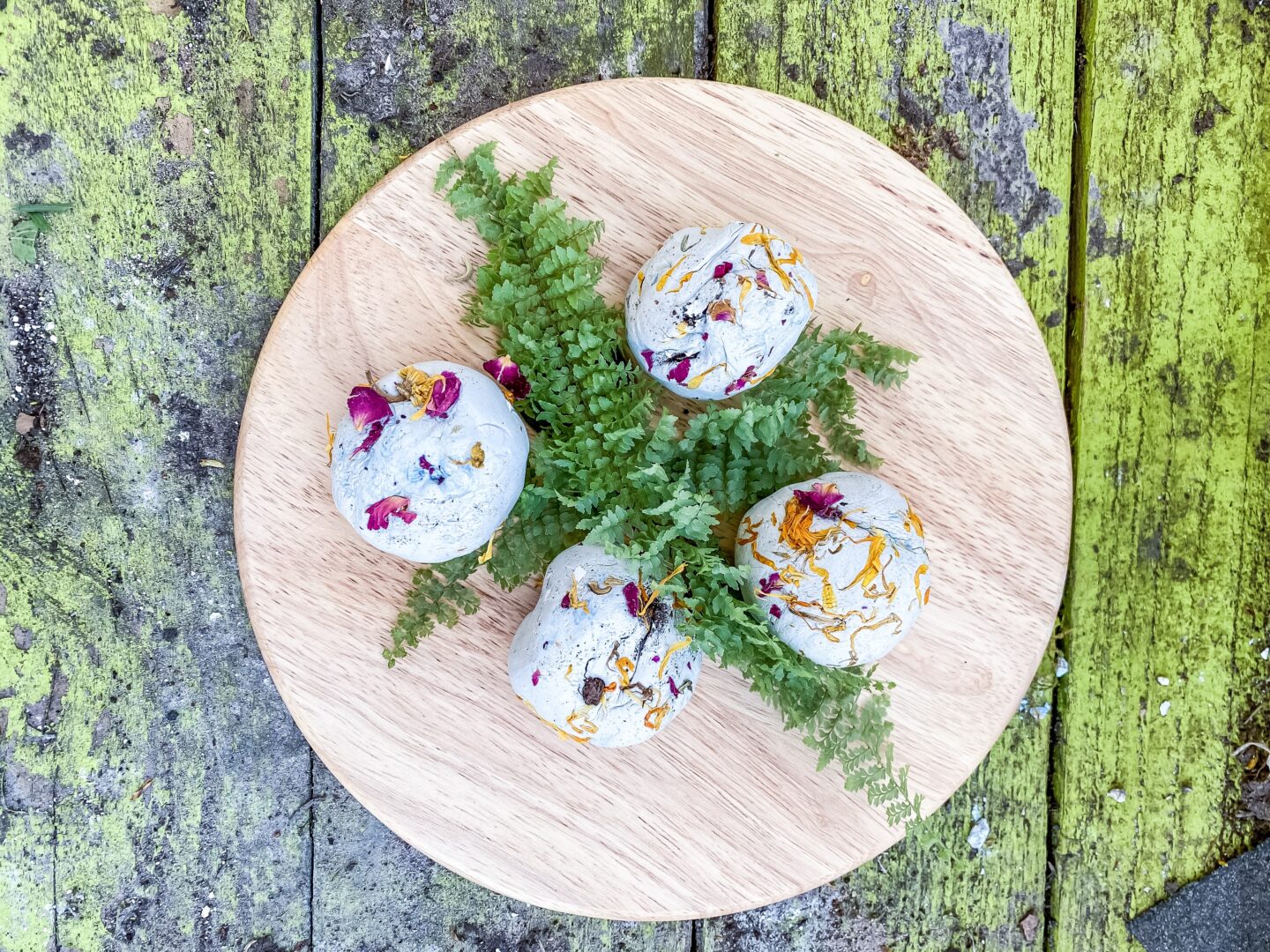 a wood plate with clay seed bombs and leaves for May activities with kids