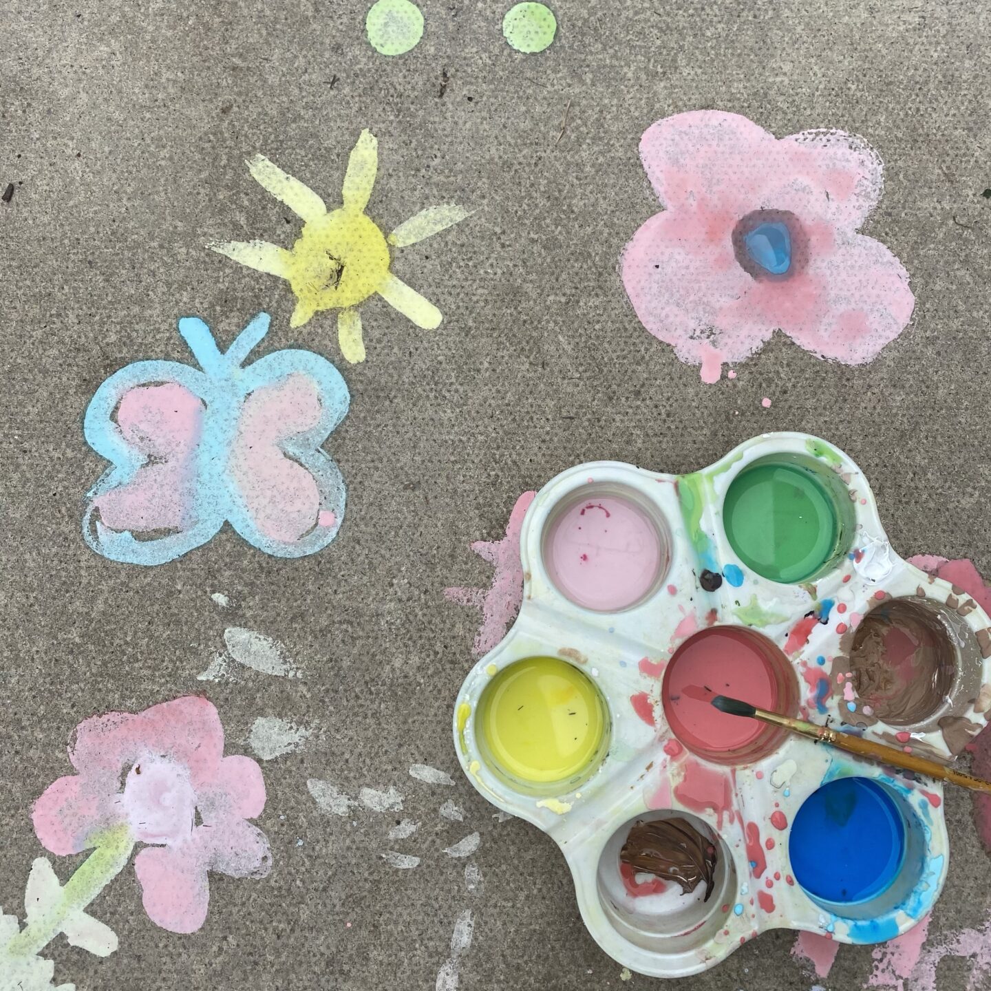 June activities for kids Outdoor chalk paint pictures on the patio floor 