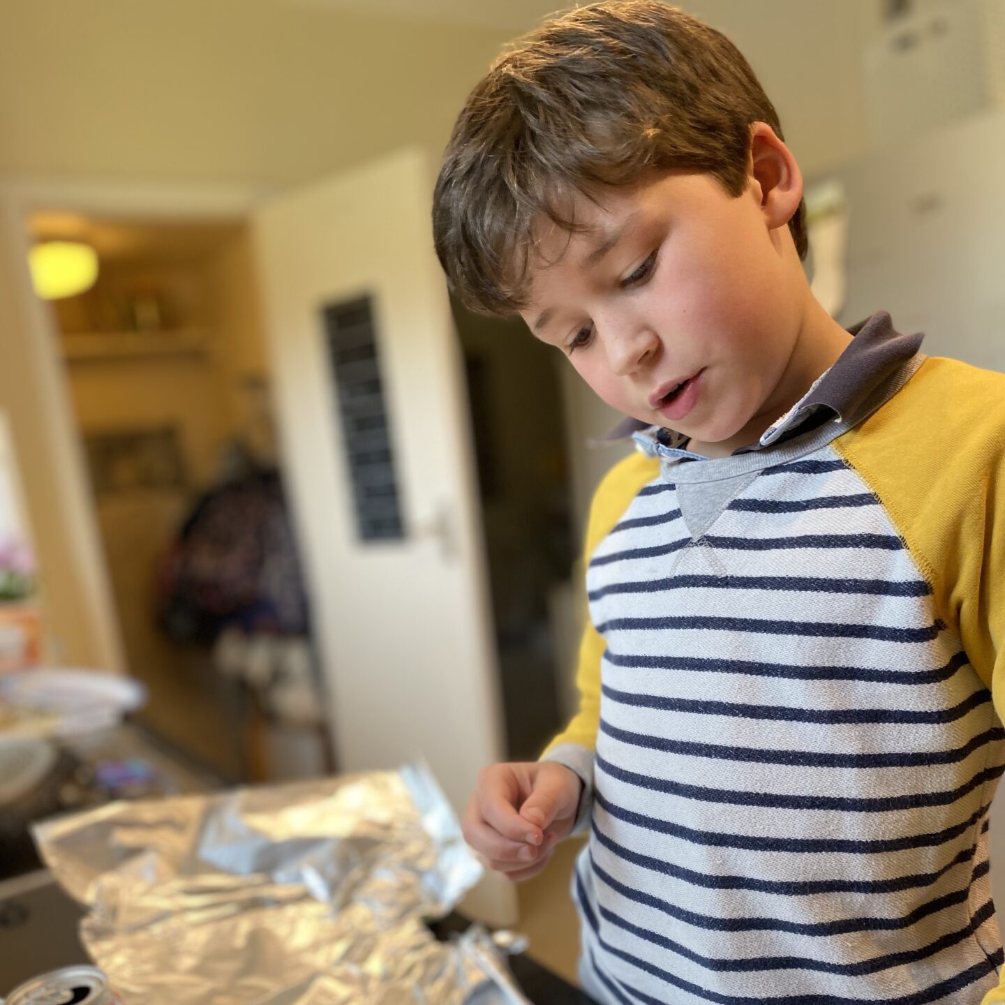 family life with a boy concentrating on baking in the kitchen