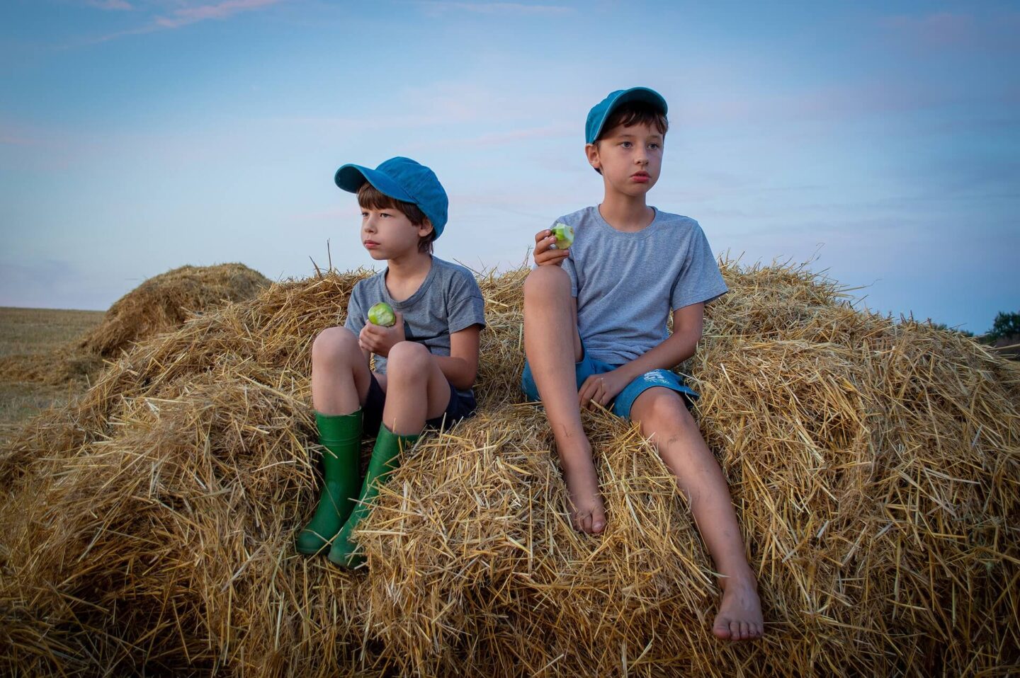 exploring mindfulness with your child with two boys on a hay bale eating apples looking at nature