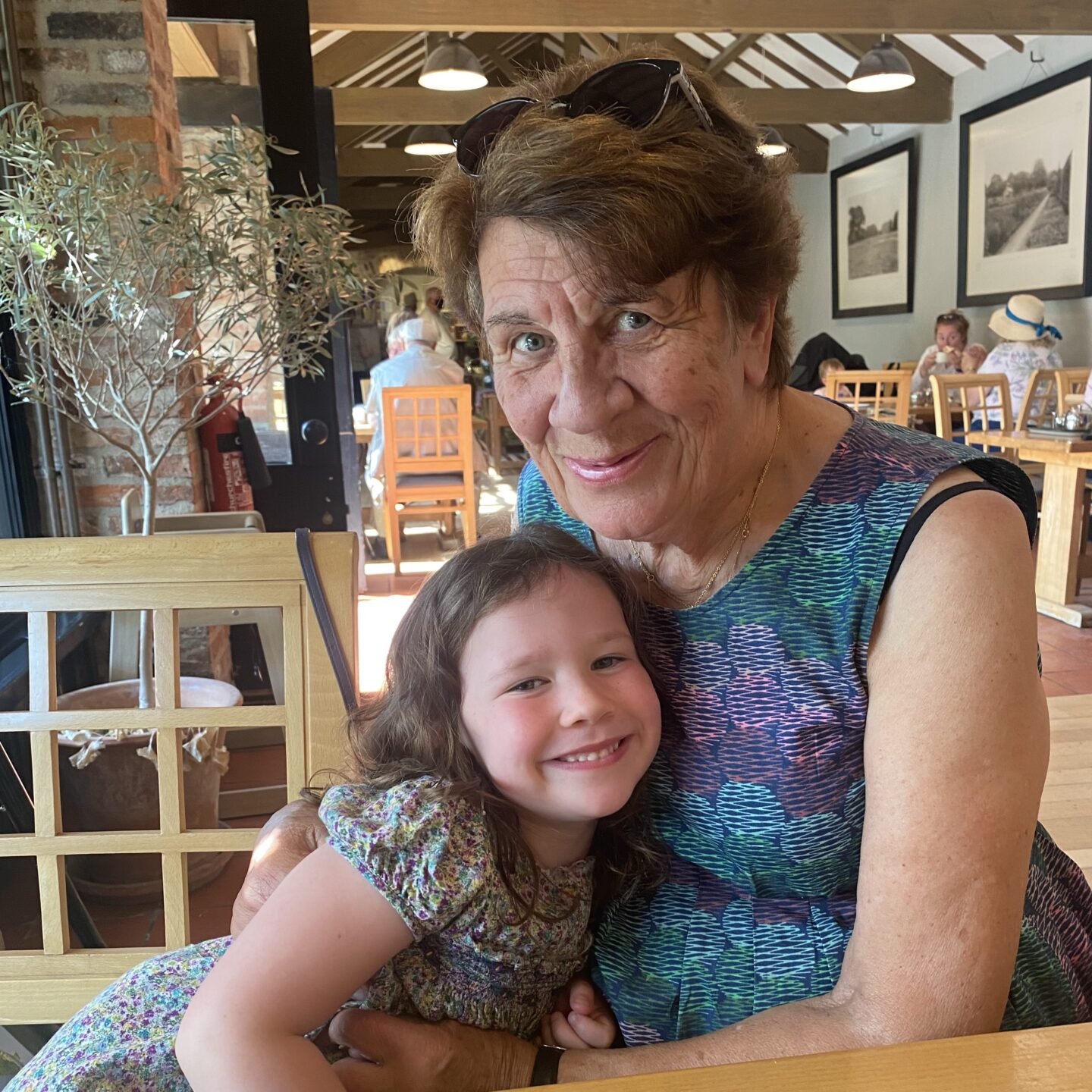 a grandma and granddaughter cuddling in a cafe